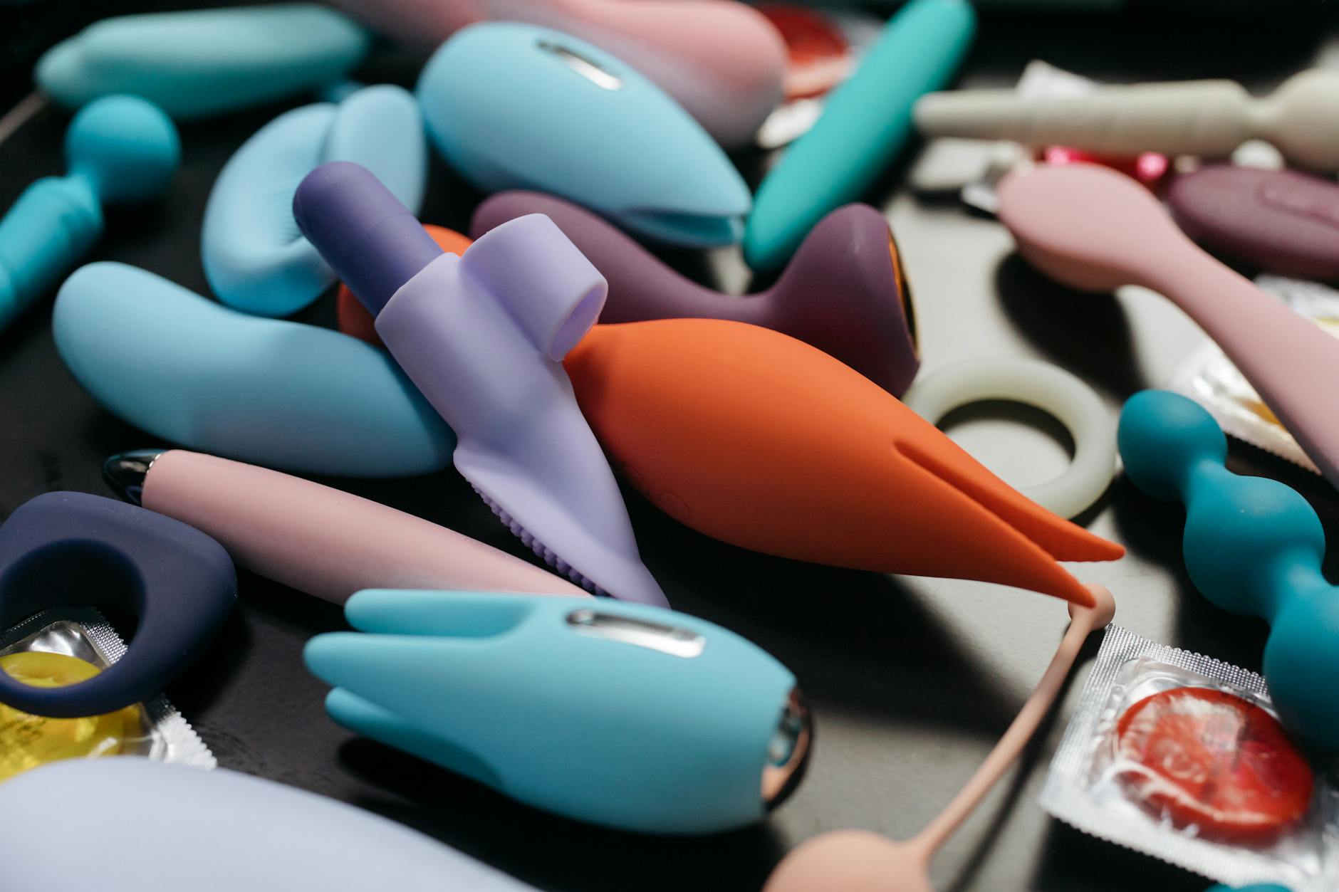 Mujer sosteniendo un vibrador de limón rosa, con libros de arte al fondo