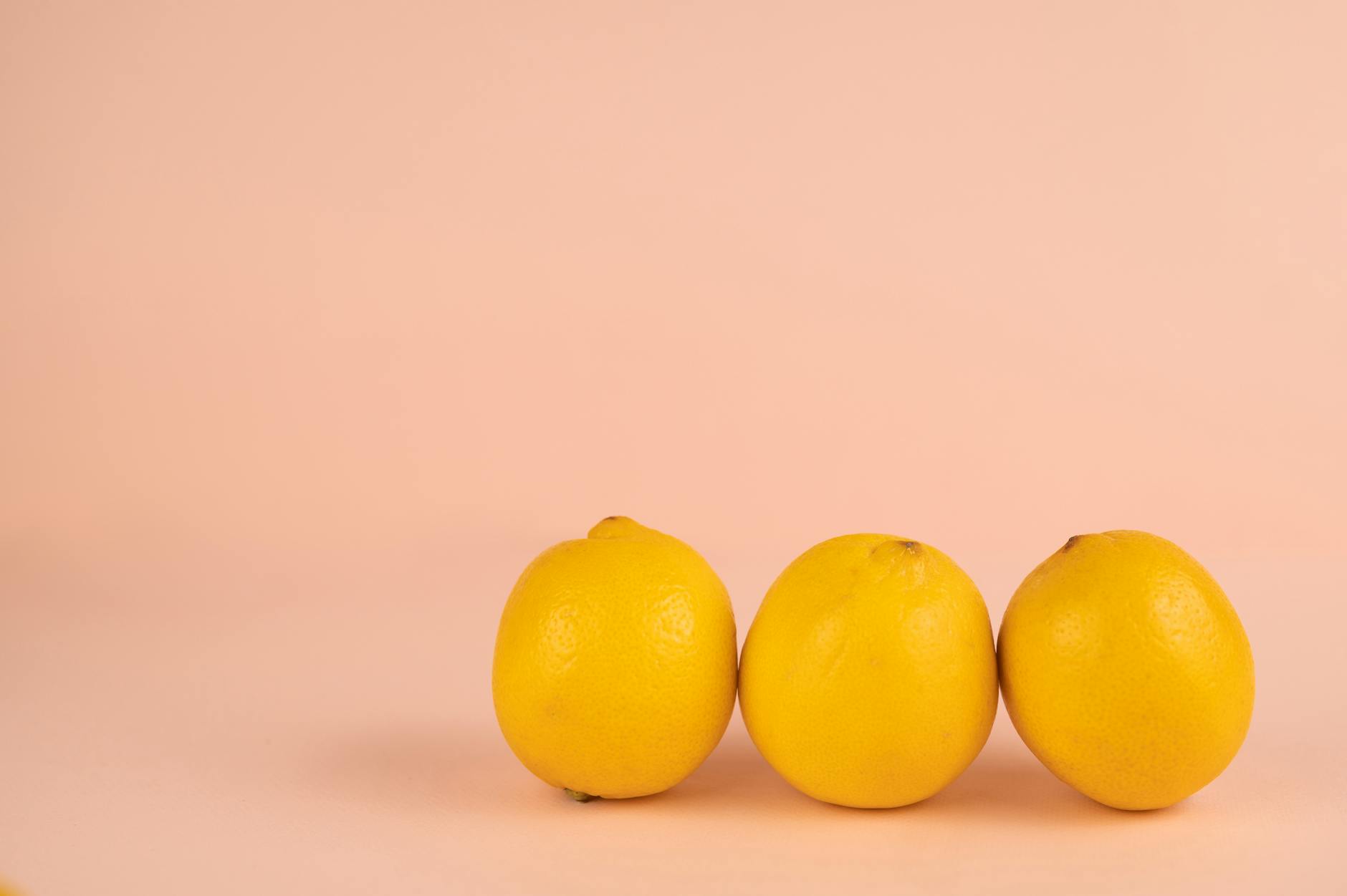 Limones frescos en fila sobre fondo pastel